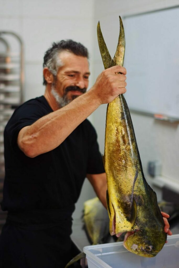 Julien, le chef cuisinier avec une belle dorade en cuisine