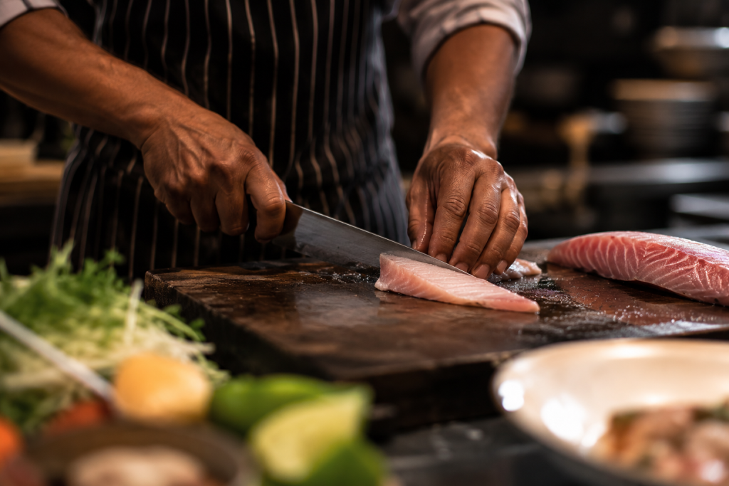 cuisinier découpant du poisson frais la paillote bleue Deshaies